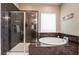 Beautiful bathroom showcases a soaking tub and glass enclosed shower with luxurious marble tile at 2896 Grande Arch St, Henderson, NV 89044