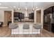 Bright kitchen with an island bar with granite countertop, modern lighting, and stainless steel appliances at 2896 Grande Arch St, Henderson, NV 89044