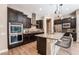 Spacious kitchen featuring dark cabinetry, stainless steel appliances, and a granite countertop island with bar seating at 2896 Grande Arch St, Henderson, NV 89044