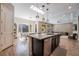Open concept kitchen with dark cabinetry, an island bar and a combined view of dining and living areas at 2896 Grande Arch St, Henderson, NV 89044