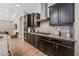 This is a kitchen with dark wood cabinets, stainless steel appliances, and a granite countertop with tiled backsplash at 2896 Grande Arch St, Henderson, NV 89044