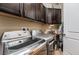 This laundry room features dark wood cabinets, a sink, and a modern washer and dryer at 2896 Grande Arch St, Henderson, NV 89044