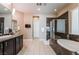 Open concept bathroom with double vanity, a glass shower, soaking tub, and tiled flooring at 2896 Grande Arch St, Henderson, NV 89044