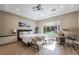 Relaxing bedroom with a ceiling fan, tray ceiling, and a view of the outdoor pool and patio area at 2896 Grande Arch St, Henderson, NV 89044