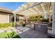 Backyard outdoor kitchen with built-in grill and pergola-covered dining area at 2896 Grande Arch St, Henderson, NV 89044