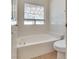 Bright bathroom featuring a soaking tub under a window and a tiled backsplash at 2904 Channel Bay Dr, Las Vegas, NV 89128