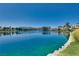 Scenic lake view with clear water, lush greenery, and homes in the background at 2904 Channel Bay Dr, Las Vegas, NV 89128