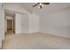 Bright main bedroom featuring neutral carpeting, a ceiling fan, and access to a hallway and ensuite at 2904 Channel Bay Dr, Las Vegas, NV 89128