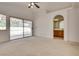 Open main bedroom featuring neutral carpeting, a ceiling fan, and access to a backyard patio area and ensuite at 2904 Channel Bay Dr, Las Vegas, NV 89128