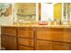 Bathroom features wood cabinets, granite countertops, a large mirror, and an open view into the shower at 3436 N Tenaya Way, Las Vegas, NV 89129