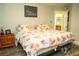 Bright bedroom with floral bedding, featuring a nightstand and door leading to an ensuite bathroom at 3436 N Tenaya Way, Las Vegas, NV 89129
