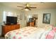 Comfortable bedroom with large dresser, ceiling fan, and plush floral bedding for a relaxing night's sleep at 3436 N Tenaya Way, Las Vegas, NV 89129