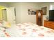 Comfortable bedroom with floral bedding, featuring a nightstand and view into another room with artwork at 3436 N Tenaya Way, Las Vegas, NV 89129