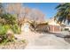 Beautiful home with a landscaped front yard, mature trees, and a curved driveway leading to a two-car garage at 3436 N Tenaya Way, Las Vegas, NV 89129
