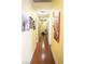 Inviting hallway adorned with pictures, featuring warm yellow walls and wood-look floors at 3436 N Tenaya Way, Las Vegas, NV 89129