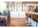 Bright kitchen featuring wood floors, a breakfast bar, and a white china cabinet to display dishware and accessories at 3436 N Tenaya Way, Las Vegas, NV 89129