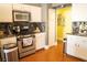 Charming kitchen with stainless steel appliances, white cabinets and wood flooring at 3436 N Tenaya Way, Las Vegas, NV 89129