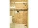 A luxurious shower area with designer tile accents and a built-in shelf for storage and organization at 3436 N Tenaya Way, Las Vegas, NV 89129