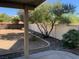 View of the backyard that features a patio, rock landscaping, and shade tree at 3728 Prairie Orchid Ave, North Las Vegas, NV 89081