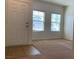 Light and bright entryway with neutral carpet, tile entry and large windows at 3728 Prairie Orchid Ave, North Las Vegas, NV 89081