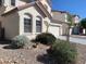 Desert landscaping surrounds this two-story home featuring multiple architectural window designs at 3728 Prairie Orchid Ave, North Las Vegas, NV 89081