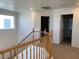 Hallway with a wooden railing and plush carpet leading to bedrooms and other living areas at 3728 Prairie Orchid Ave, North Las Vegas, NV 89081