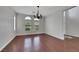 Elegant dining room with wood floors, a chandelier, and large windows offering natural light at 3728 White Lion Ln, North Las Vegas, NV 89084