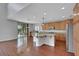 Open kitchen with an island, granite counters, wood cabinets, and sliding glass doors to the backyard at 3728 White Lion Ln, North Las Vegas, NV 89084