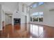 Open living room with hardwood floors, a fireplace, and expansive windows with backyard views at 3728 White Lion Ln, North Las Vegas, NV 89084