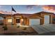 Charming home featuring a three-car garage, desert landscaping, and a prominent American flag at 3811 Queen Elizabeth Ct, Laughlin, NV 89029