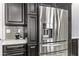 Close-up of stainless steel refrigerator with dark wood cabinets and tiled backsplash at 3811 Queen Elizabeth Ct, Laughlin, NV 89029