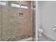 Nicely tiled shower stall featuring river rock flooring, glass doors, and window at 4016 Owlshead Mountain St, Las Vegas, NV 89129