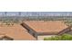 A scenic view of the cityscape from atop a community, featuring neighboring homes with red-tiled roofs at 4016 Owlshead Mountain St, Las Vegas, NV 89129