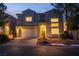 Beautiful home featuring a two-car garage, manicured landscaping, and warm exterior lighting at 4016 Owlshead Mountain St, Las Vegas, NV 89129