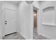 Bright hallway featuring tile floors, white walls, and access to a bathroom with tiled shower stall at 4016 Owlshead Mountain St, Las Vegas, NV 89129