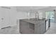 Modern kitchen features an island with gray cabinets, stone countertops, and stainless steel appliances at 4016 Owlshead Mountain St, Las Vegas, NV 89129