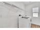 Bright laundry room with modern washer, dryer, and shelving at 4016 Owlshead Mountain St, Las Vegas, NV 89129