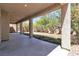 A covered patio area with concrete flooring, providing shade and a view of the backyard landscaping at 4016 Owlshead Mountain St, Las Vegas, NV 89129