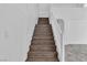 An interior shot of a wooden staircase, set against white walls, leading to a multi-level home at 4016 Owlshead Mountain St, Las Vegas, NV 89129