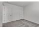 A simple bedroom featuring neutral carpet, white walls, and two doors at 4448 Mahogany Hills Ave, Las Vegas, NV 89141