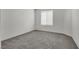 A simple bedroom featuring neutral carpet, white walls, and a large window at 4448 Mahogany Hills Ave, Las Vegas, NV 89141
