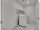 A bright laundry area includes a washing machine, dryer and shelving at 4448 Mahogany Hills Ave, Las Vegas, NV 89141