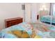 Well-lit bedroom featuring a bright quilt, dresser, and view into another bedroom at 4970 Black Bear Rd # 101, Las Vegas, NV 89149