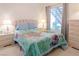 Inviting bedroom with a bright quilt, bedside tables, and a view of the exterior stairway at 4970 Black Bear Rd # 101, Las Vegas, NV 89149