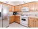 Functional kitchen boasting wood cabinets, white appliances, and ample counter space at 4970 Black Bear Rd # 101, Las Vegas, NV 89149