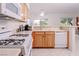 Efficient kitchen featuring a gas range, white appliances, wood cabinets, and adjacent breakfast bar at 4970 Black Bear Rd # 101, Las Vegas, NV 89149