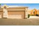 View of a home's two-car garage with an adjacent home entrance with an arch at 5316 Fieldstone Rd, Las Vegas, NV 89107