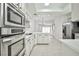 Open kitchen view showcasing white cabinets, stainless steel appliances, and tile flooring at 5316 Fieldstone Rd, Las Vegas, NV 89107