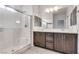 Modern bathroom with double sink vanity, large mirror, and walk-in shower with seat at 538 Ylang Pl, Henderson, NV 89015