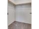 Empty walk-in closet with neutral carpet, white walls, and a wooden hanging rod for storage at 538 Ylang Pl, Henderson, NV 89015